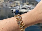 a person that is holding a bracelet near a body of water