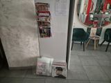 un réfrigérateur sur lequel sont posés des magazines, dans une pièce