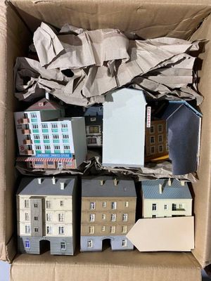 une boîte en carton remplie de petites maquettes de maisons et de bâtiments