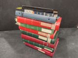 many books stacked on top of each other on a table