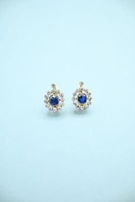 a pair of sapphire and diamond earrings on a white background
