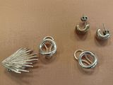 three pairs of earrings and a ring on a table