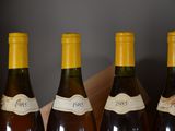 four bottles of wine are lined up in a row on a table