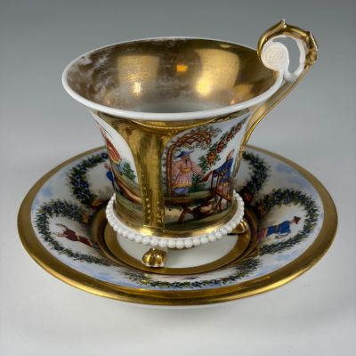 an antique cup and saucer on a saucer with a gold rim