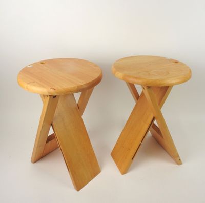 two small wooden stools sitting next to each other on a white surface