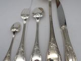 five silver spoons and two silver spoons on a table