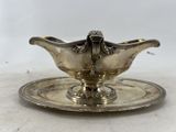 an antique silver plate with a saucer on it on a table