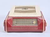 an old red and white radio sitting on top of a white table