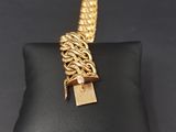 a gold chain bracelet with a padlock on a black pillow