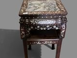 a small table with a marble top on a gray background