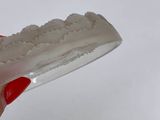 a person holding a toothbrush over a bowl of toothpaste