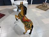a wooden horse that is standing on its hind legs