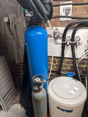 un réservoir bleu et un seau blanc dans une pièce