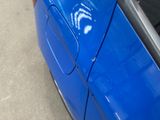a close up of a blue car with a sticker on it