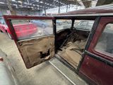 a red car with the door open sitting in a garage