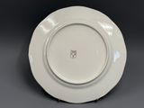 a close up of a white plate with a crest on it