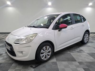 the small white car is parked on a checkered tile floor