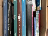 de nombreux livres dans une boîte en carton posée sur la table