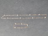 deux colliers en argent et en or, ornés de perles, sur un fond gris