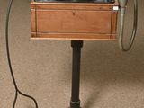 a record player sitting on a stand with a laptop on top