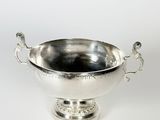 un bol antique en métal argenté avec des poignées sur un piédestal