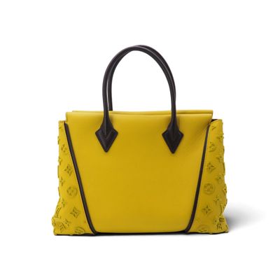 un sac à main jaune avec des anses noires sur fond blanc
