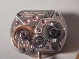 a close up of a watch movement on a white surface