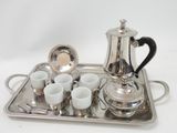 a silver tray with cups and a silver tea pot on it