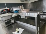 plan de travail en acier inoxydable dans une cuisine commerciale équipée d'appareils en acier inoxydable