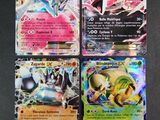 quatre cartes Pokémon différentes posées sur une table avec un fond noir