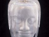 a glass vase with a face on it on a black background