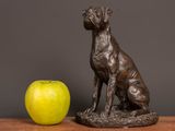 a statue of a dog and an apple on a table