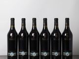 six bouteilles de vin sont alignées sur une table en bois