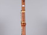 a close up of a wooden clarinet on a clear surface