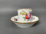 a close up of a cup and saucer on a table