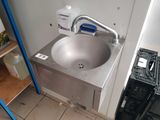un lavabo dans un coin de la salle de bains, équipé d'un robinet