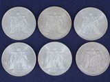 six pièces d'argent sur lesquelles figurent l'effigie d'un homme et d'une femme