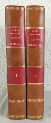 deux vieux livres reliés en cuir posés sur une table blanche