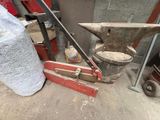 a hammer, an anvil, and a bag of sand on the ground