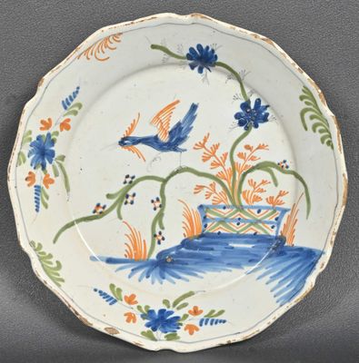 une assiette bleue et orange décorée d'un oiseau et de fleurs
