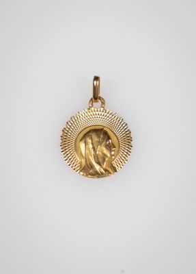 a gold pendant with an image of a woman in a sunburst