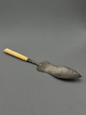 a silver spoon with a wooden handle sitting on top of a gray surface