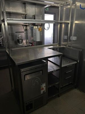 une cuisine équipée d'armoires en acier inoxydable et d'un réfrigérateur