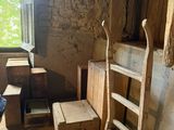 une pièce avec une échelle, une chaise, une table et une fenêtre