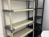 a white toilet sitting next to a shelf in a bathroom