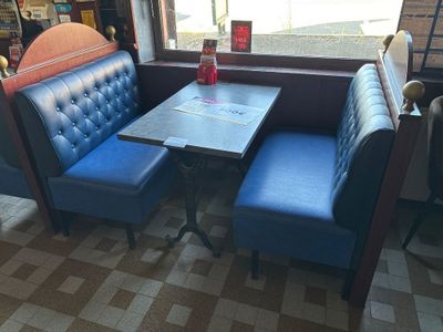 a blue booth with a table and two blue chairs