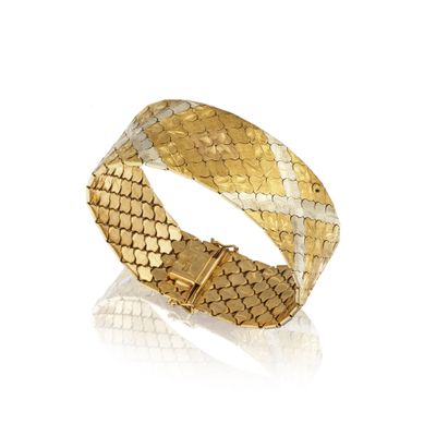 gros plan d'un bracelet en or sur fond blanc