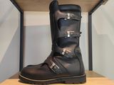 une paire de bottes noires posée sur une étagère en bois dans une pièce