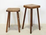 two wooden stools sitting next to each other against a white wall
