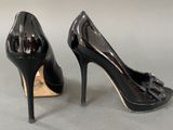 black high heeled shoes with a bow on the toe
